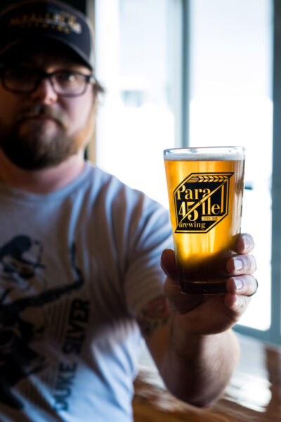 Parallel 45 Brewing co-owner Ryan Booth holding beer in custom glass