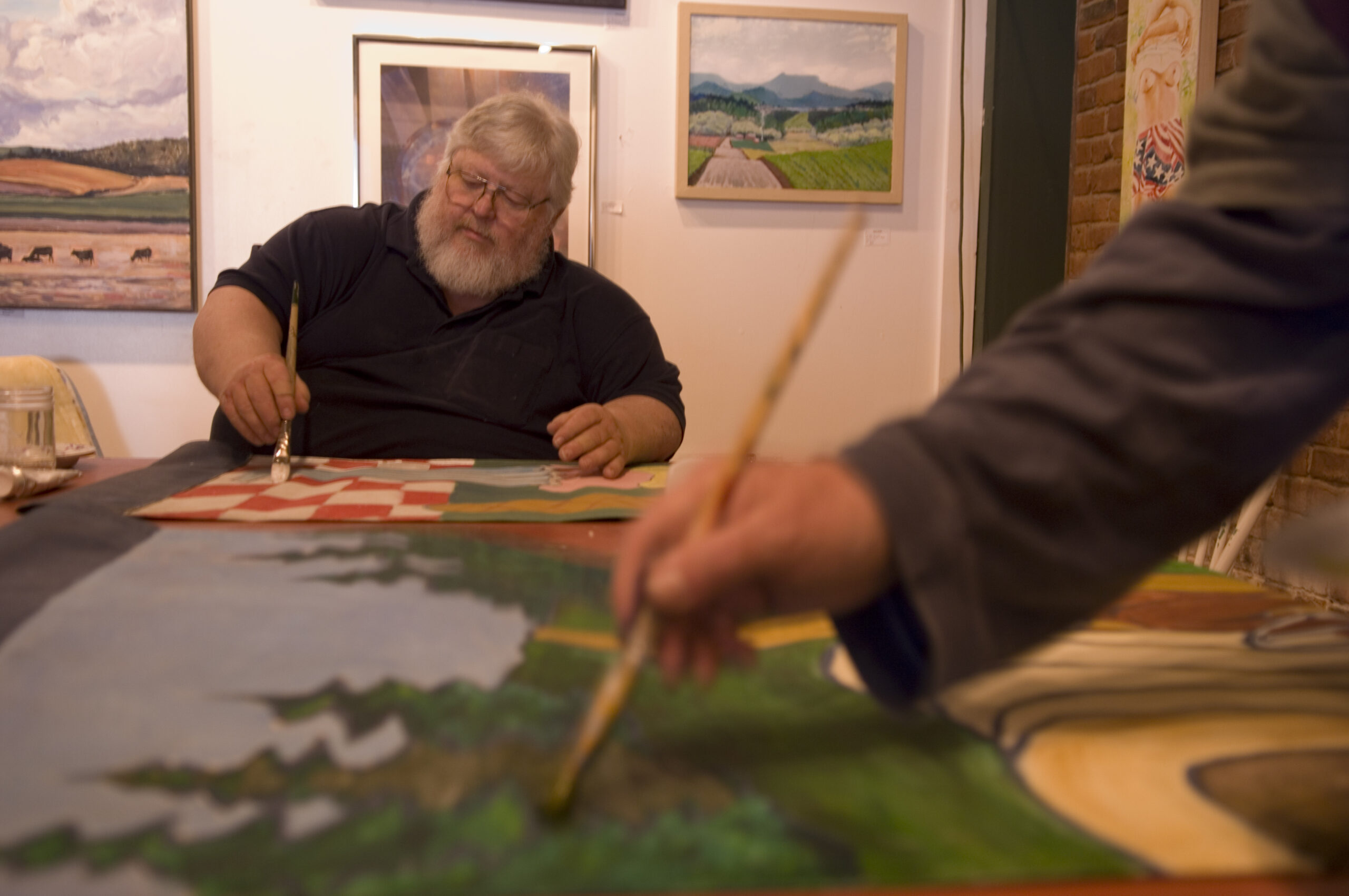 Riverview Gallery artists painting art banners to be hung on light posts around Independence Oregon
