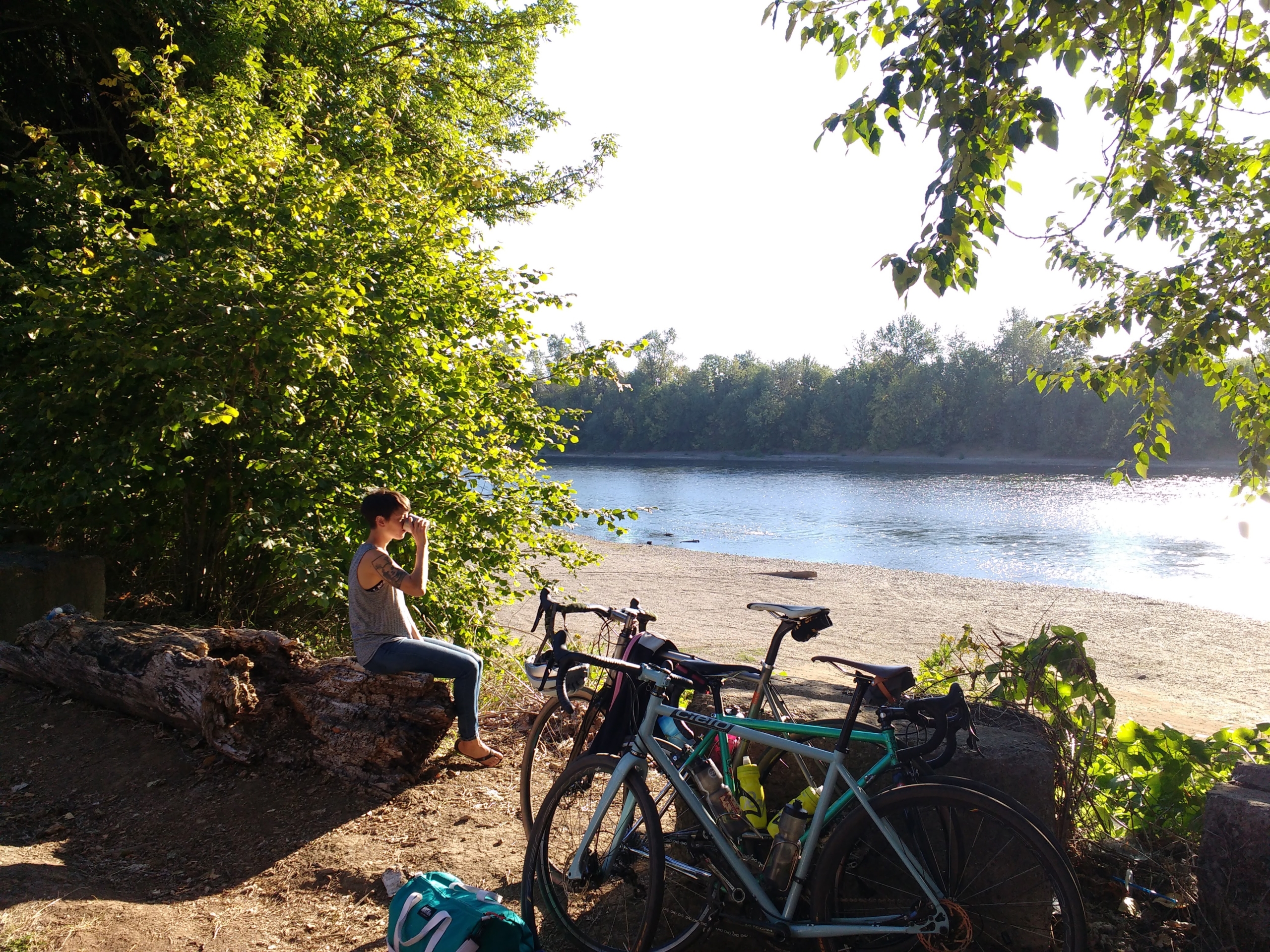 A woman drinking coffee in the morning by the river