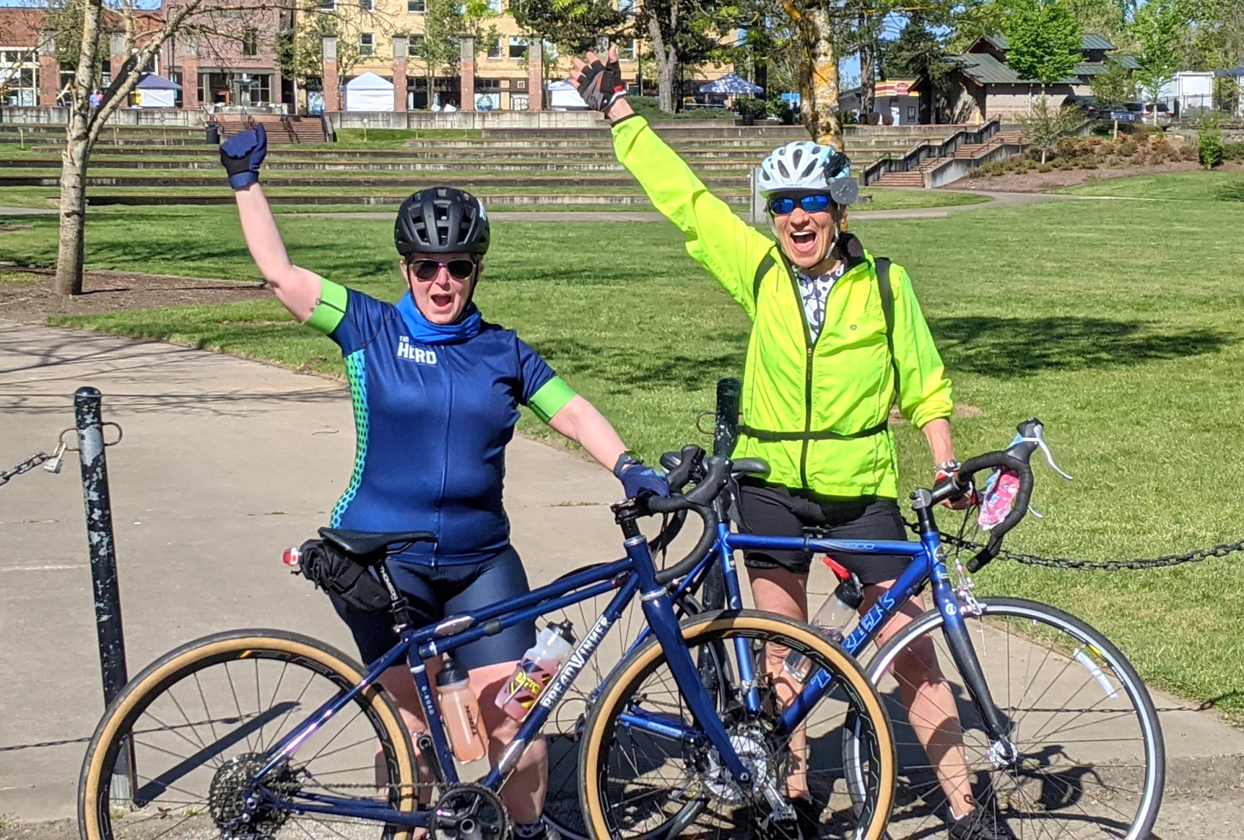 Two ladies with bikes celebrate finishing their ride