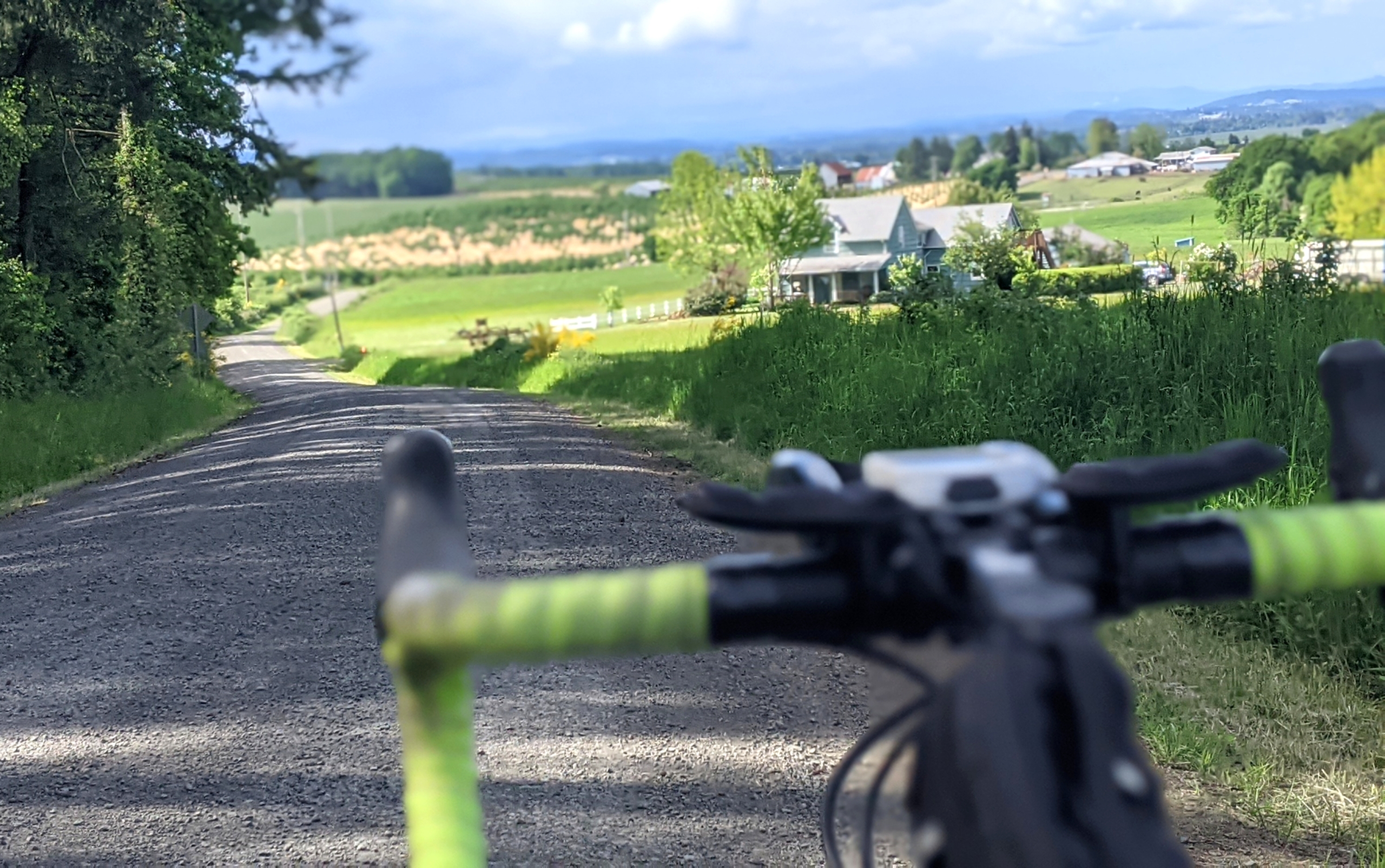 A view of farmland over bike handlebars